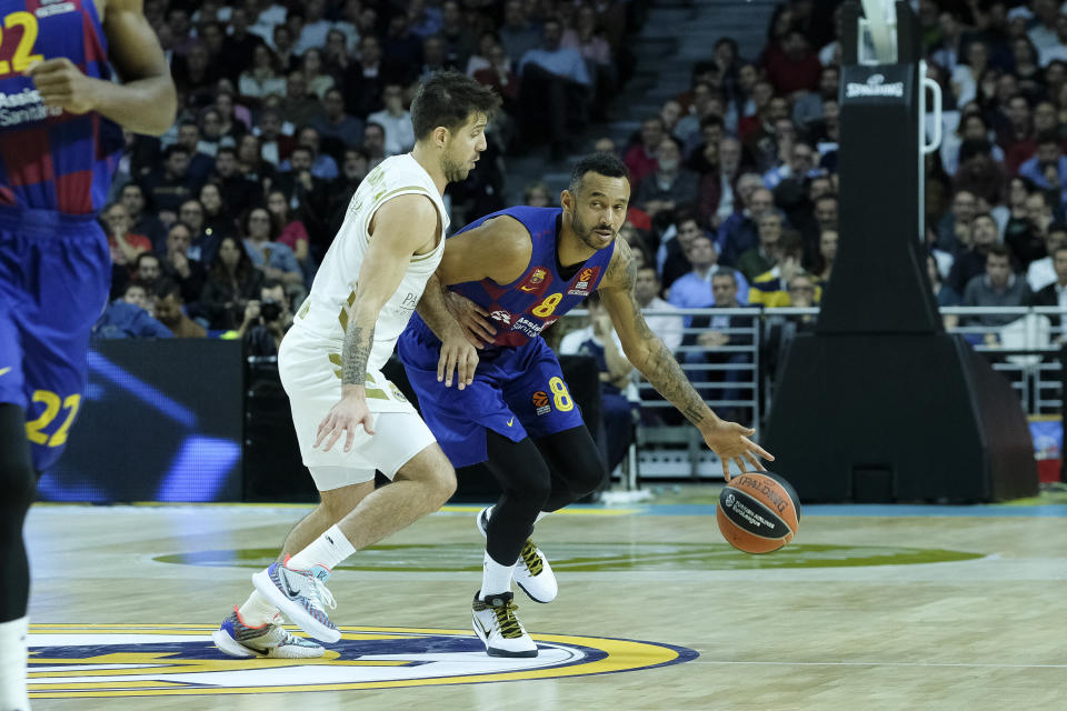 un jugador del Barcelona de baloncesto conduce la pelota ante la defensa del Real Madrid durante un partido de Euroliga.