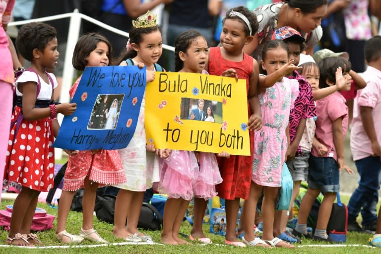 Fijian children hold banners to welcome Prince Harry and his wife Meghan