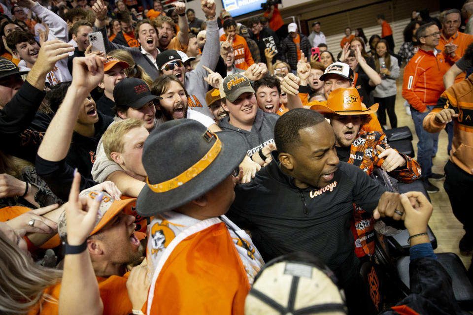 Oklahoma State head coach Mike Boynton, Jr. celebrates with fans after a 61-59 victory against Iowa State in the NCAA college basketball game in Stillwater, Okla., Saturday, Jan. 21, 2023. (AP Photo/Mitch Alcala)