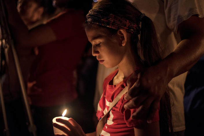 Sofia Martinez, 9, attends a candlelight vigil after a mass shooting at the First Baptist Church.