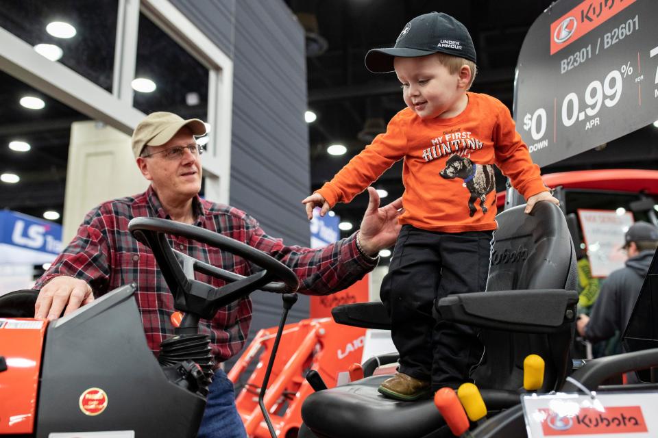 Jim Wheatley, left, helps his grandson, Jackson Wheatley, 3, explore a Kubota B2601 at the National Farm Machinery Show at the Kentucky Expo Center on Feb. 12, 2020. 