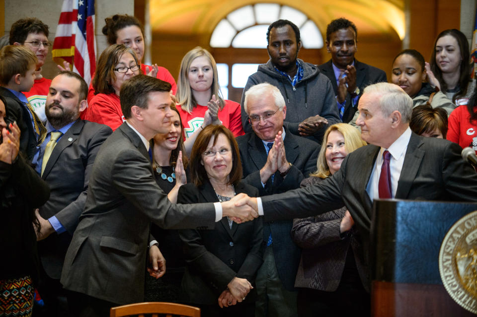 Governor Mark Dayton shakes hands with House bill author Rep. Ryan Winkler, after he signed the minimum wage bill into law at a public bill signing ceremony Monday, April 14, 2014 at the Minnesota State Capitol Rotunda in St. Paul. Minnesota goes from having one of the nation's lowest minimums to among the highest. With federal wage legislation stuck in Congress, states are rushing to fill the void. (AP Photo/The Star Tribune, Glen Stubbe) MANDATORY CREDIT; ST. PAUL PIONEER PRESS OUT; MAGS OUT; TWIN CITIES TV OUT