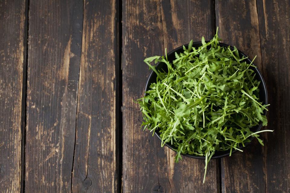 Bowl of rocket on dark wood