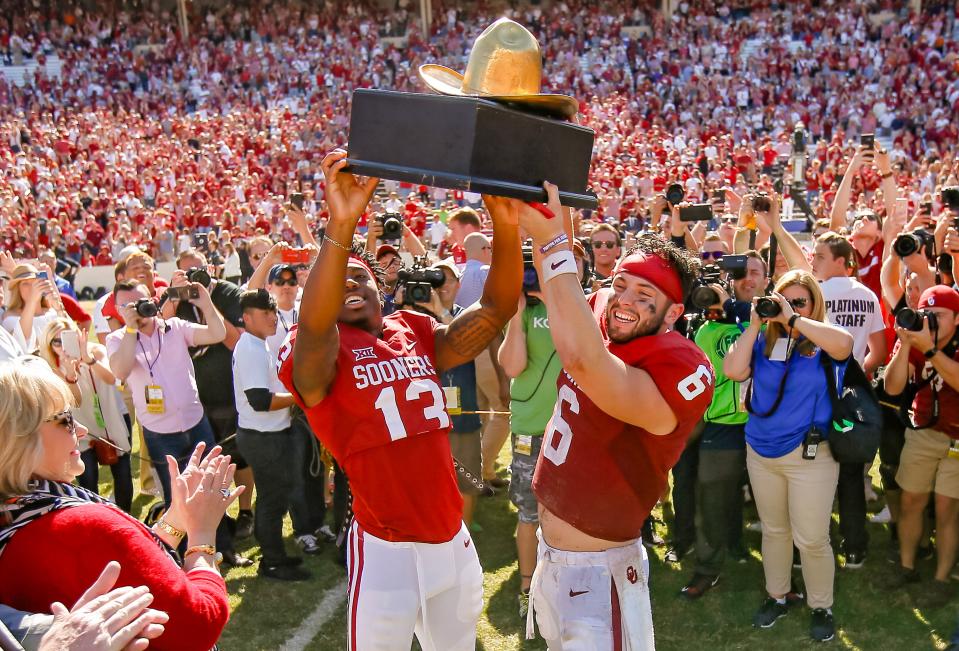 Oklahoma's Ahmad Thomas (13) and Baker Mayfield (6) hold up the Golden Hat trophy after the Red River Showdown college football game between the University of Oklahoma Sooners (OU) and the Texas Longhorns (UT) at Cotton Bowl Stadium in Dallas, Saturday, Oct. 8, 2016. Oklahoma won 45-40.