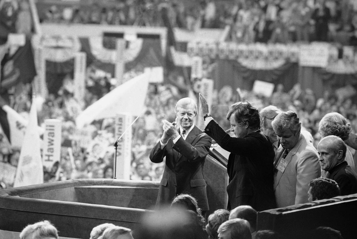 President Jimmy Carter applauds as Sen. Edward Kennedy waves to cheering crowds of the Democratic National Convention in New York's Madison Square Garden, Aug. 14, 1980.  (Bob Daugherty/AP)