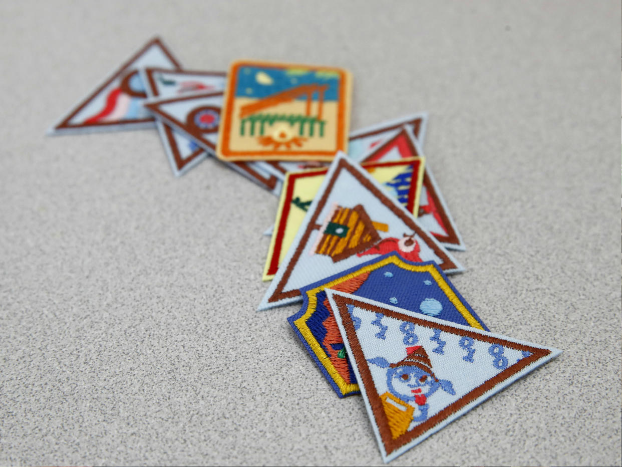 A Girl Scout badge for learning how to program a robot is seen atop a sample of new badges focused on science, technology, engineering and math in Owings Mills, Md. The new group of 23 badges takes a progressive approach to STEM and also nudges girls to become citizen scientists using the great outdoors as their laboratory. 21 July 2017: AP Photo/Patrick Semansky