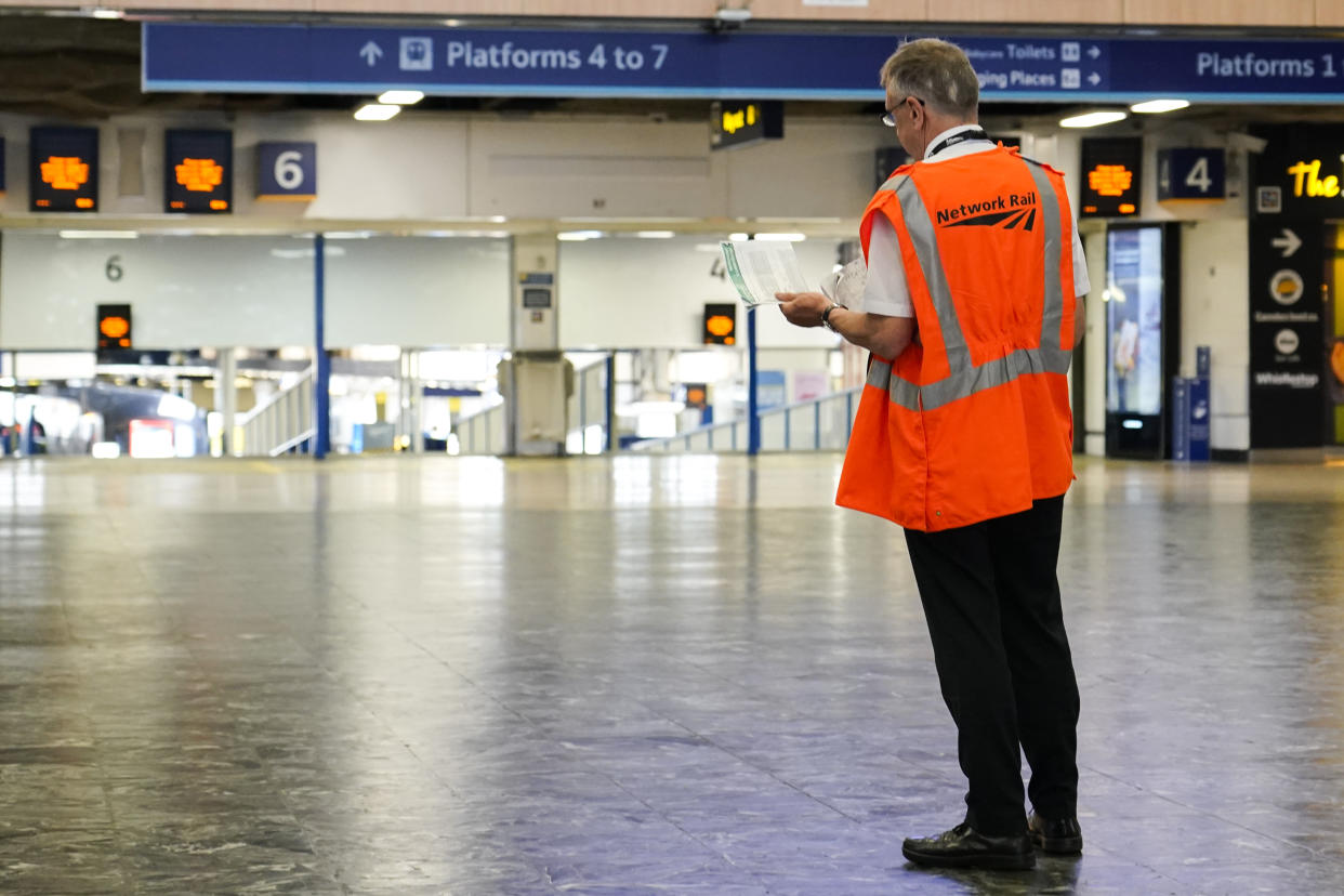 A member of staff stands at a quiet Euston station, in London, Tuesday, June 21, 2022. Tens of thousands of railway workers walked off the job in Britain on Tuesday, bringing the train network to a crawl in the country’s biggest transit strike for three decades. (AP Photo/Alberto Pezzali)