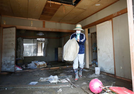 A local resident tries to clear mud and debris from his home at a flood affected area in Mabi town in Kurashiki, Okayama Prefecture, July 13, 2018. REUTERS/Issei Kato