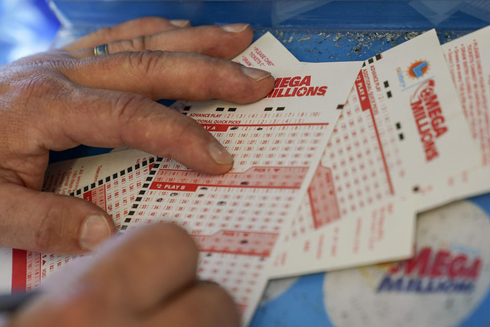 FILE - Gordon Midvale fills out a lottery ticket inside a 7-Eleven store in Oakland, Calif., Tuesday, July 26, 2022. Across the U.S., state lottery systems use that revenue to boost education, tourism, transportation and much more. Now that the giant Mega Millions lottery jackpot has ballooned to more than $1 billion, state officials are hoping increased national interest in securing the top prize will result in more funding for their own causes. (AP Photo/Godofredo A. Vásquez, File)