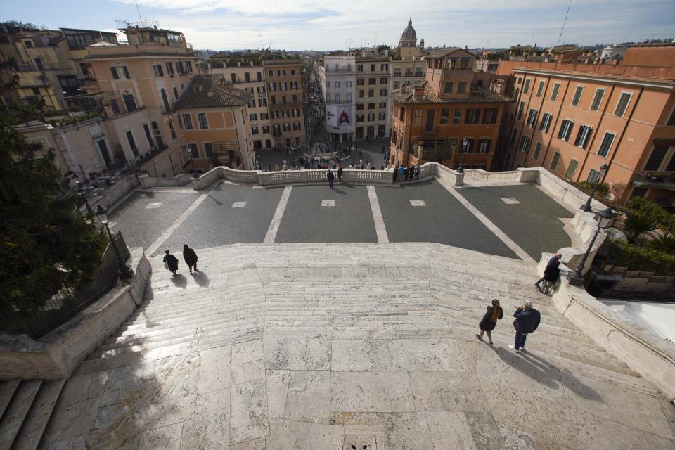 Few tourists walk along the Spanish Steps, in Rome, Thursday, March 5, 2020. Italy's virus outbreak has been concentrated in the northern region of Lombardy, but fears over how the virus is spreading inside and outside the country has prompted the government to close all schools and Universities nationwide for two weeks. (AP Photo/Andrew Medichini)