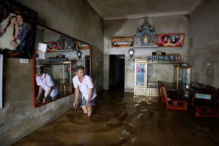 A man cleans his submerged house after heavy rainfall caused by tropical storm Son Tinh in Ninh Binh province, Vietnam, July 22, 2018. REUTERS/Kham