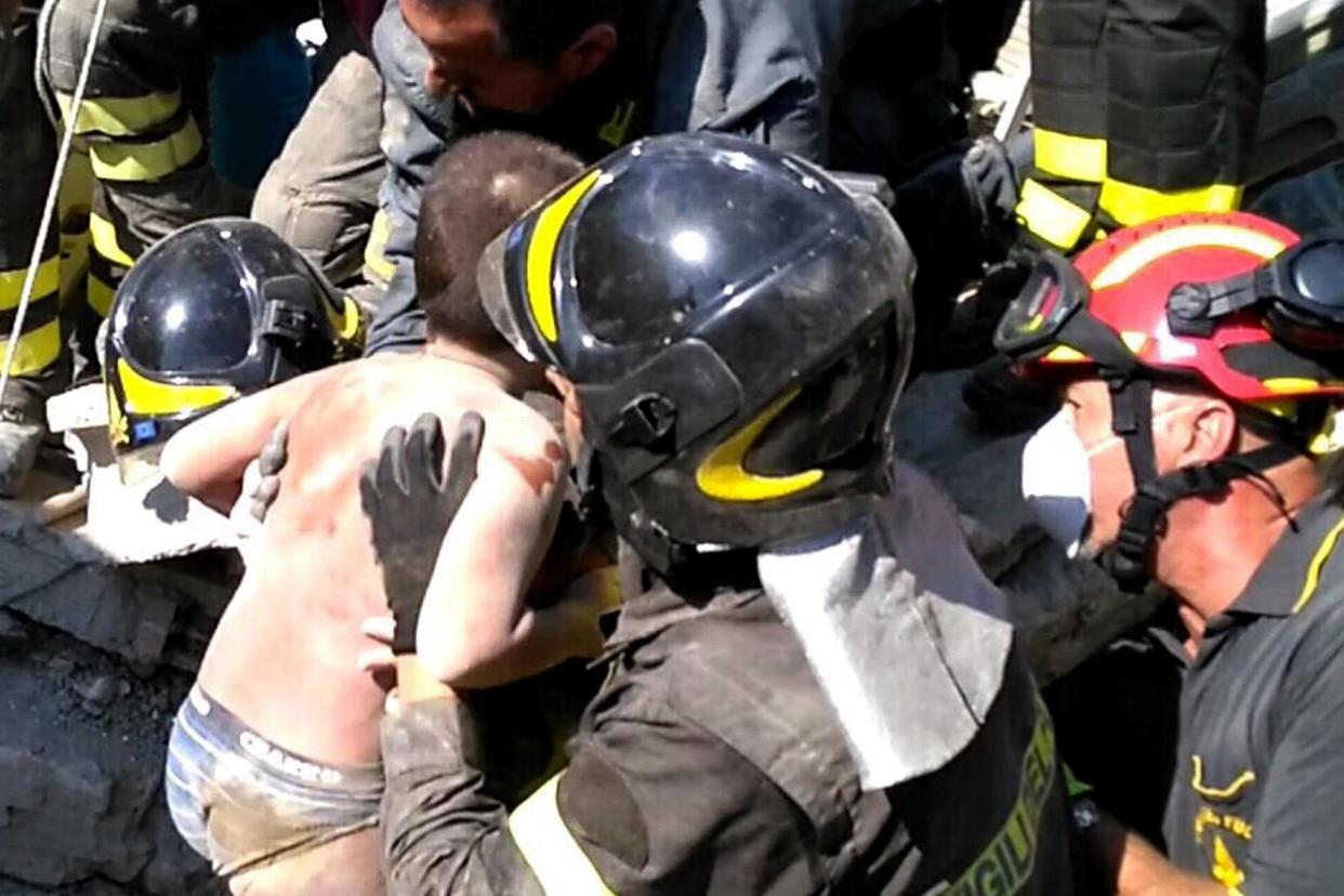 Italian firemen rescuing the youngster from the rubble: AFP/Getty Images