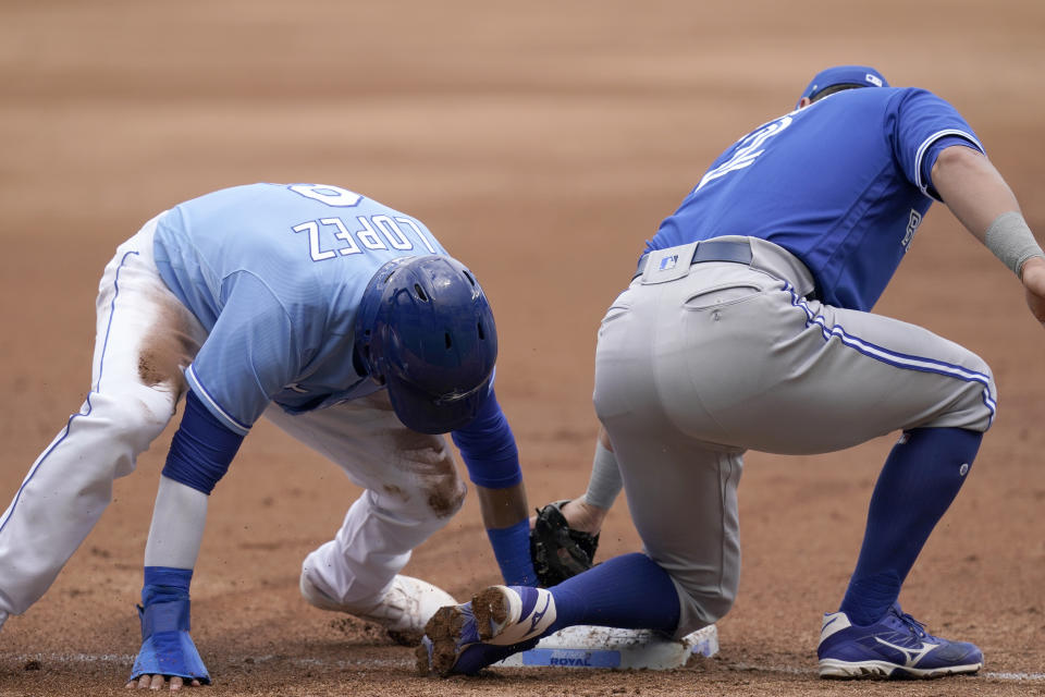 Kansas City Royals Nicky Lopez, left, beats the tag by Toronto Blue Jays second baseman Joe Panik, right, during the second inning of a baseball game at Kauffman Stadium in Kansas City, Mo., Sunday, April 18, 2021. Lopez was safe with a stolen base on the play. (AP Photo/Orlin Wagner)