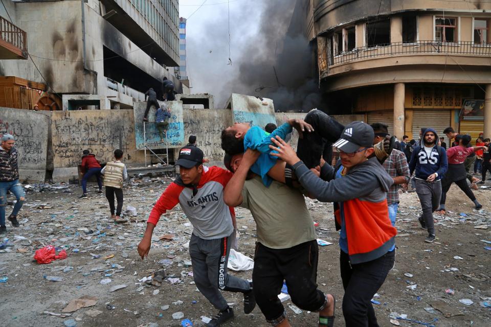 A wounded protester is carried to receive first aid during clashes with security forces on Rasheed Street in Baghdad, Iraq, Thursday, Nov. 28, 2019. Anti-government protests have gripped Iraq since Oct. 1, when thousands took to the streets in Baghdad and the predominantly Shiite south. The largely leaderless movement is accusing the government of being hopelessly corrupt, and also decries Iran's growing influence in Iraqi state affairs. (AP Photo/Khalid Mohammed)
