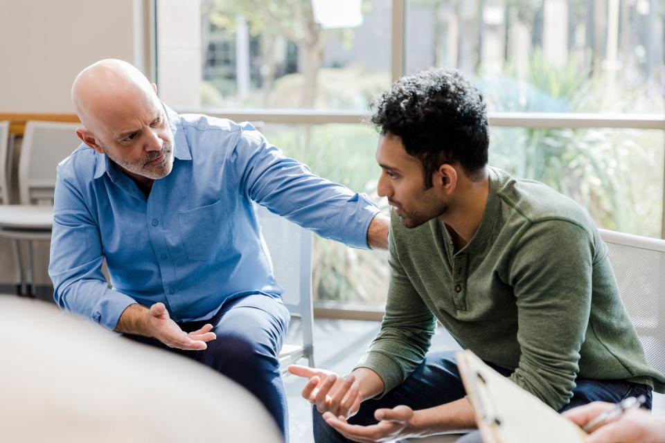 mature man helps younger man verbalize problems in therapy