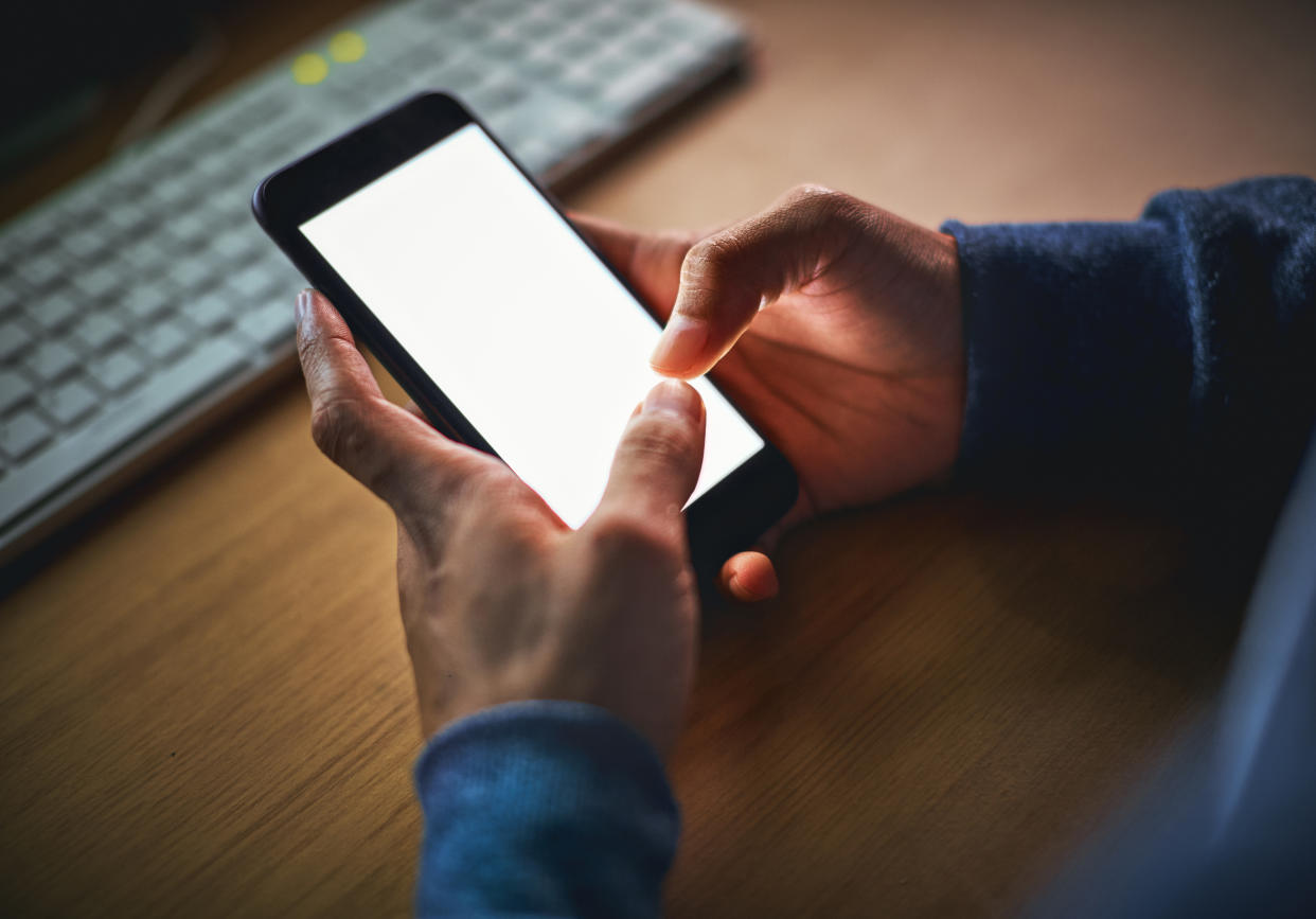 A man holding his phone. (PHOTO: Getty Images)