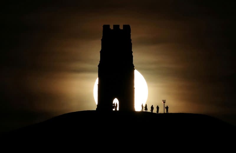 FILE PHOTO: St Michael's Tower is seen on Glastonbury Tor as a full moon rises in Glastonbury