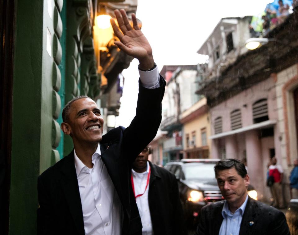 Obama waves to people as he enters a restaurant in Havana.