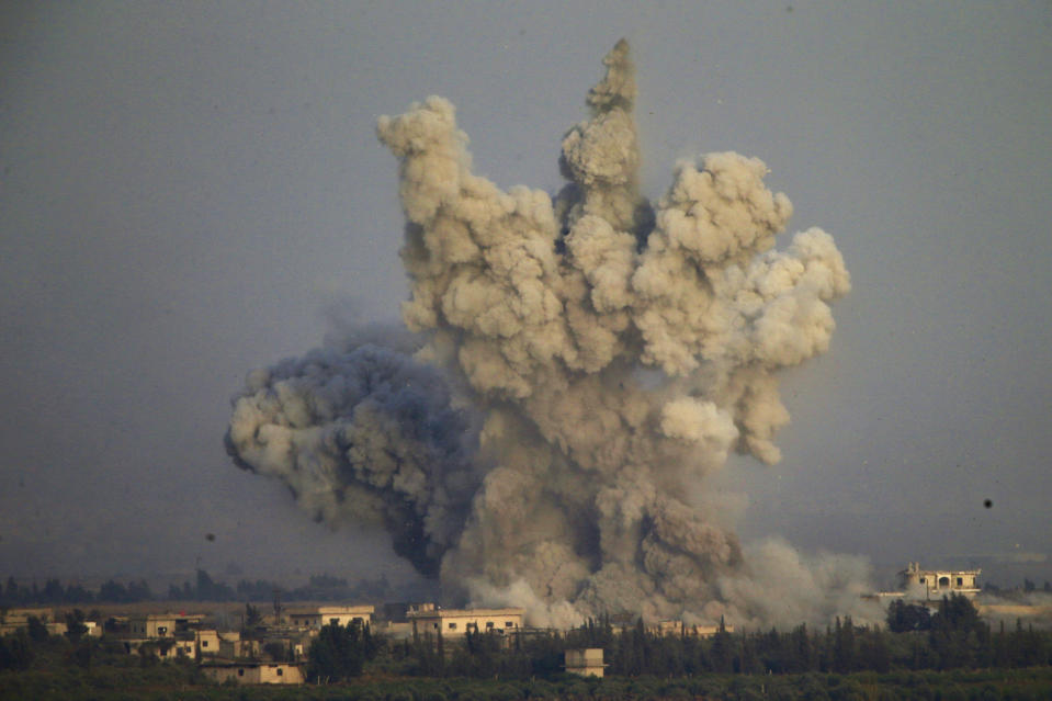 Smoke and explosions from the fighting between forces loyal to Syrian President Bashar Assad and rebels in southern Syria as seen from the Israeli-controlled Golan Heights, Wednesday, July 25, 2018. (AP Photo/Ariel Schalit)