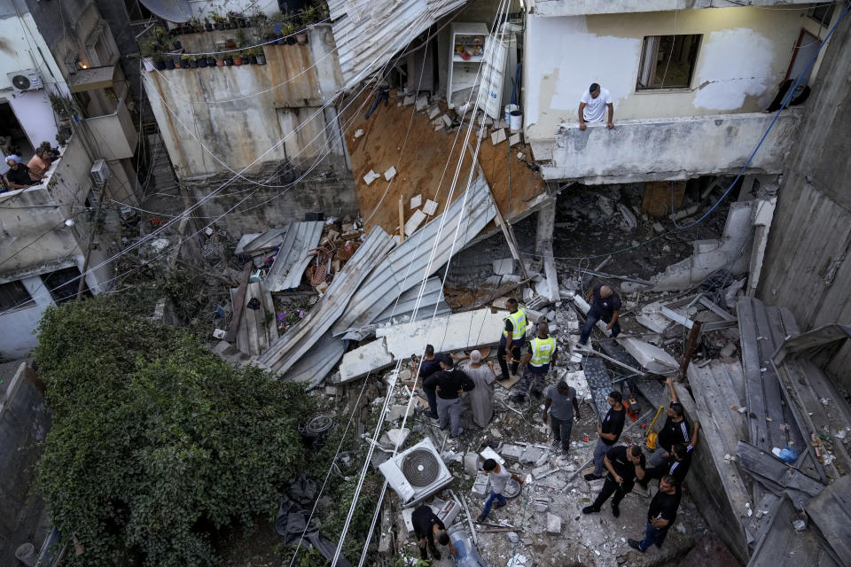 Palestinians inspect a damaged building following an Israeli army raid in Nour Shams refugee camp in the northern West Bank, Sunday, Sept. 24, 2022. Palestinians said at least two people were killed in the raid, which the army said was carried out to destroy a militant command center and bomb-storage facility in the building. (AP Photo/Majdi Mohammed)