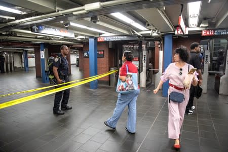 Police and commuters are seen near a closed section of the Fulton Street subway station as police investigated two suspicious packages in Manhattan