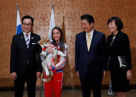 Endo Takashi, head of the Association for the preservation of the purity of the Akito breed, Russian figure skating gold medallist Alina Zagitova, Japanese Prime Minister Shinzo Abe and his wife Akie Abe poses with an Akita Inu puppy presented to Zagitova, in Moscow, Russia May 26, 2018. REUTERS/Maxim Shemetov