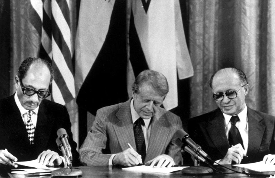 FILE - From left, Egyptian President Anwar Sadat, U.S. President Jimmy Carter, and Israeli Prime Minister Menachem Begin sign one of two agreements forged at the Camp David Summit during a joint announcement at the White House, Sept. 17, 1978. Egypt has threatened to void its decades-long peace treaty with Israel if Israel begins a large-scale offensive on Rafah, where some 1.4 million Palestinians shelter in densely-packed tent camps on the border with Egypt. (AP Photo, File)