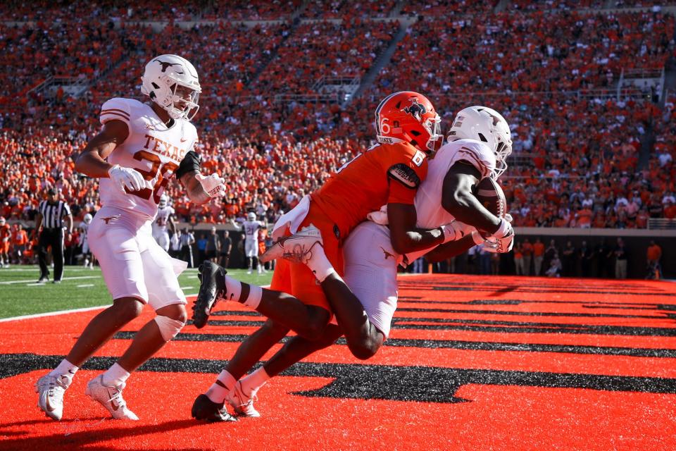 Texas defensive back Ryan Watts (6) intercepts a pass intended for Oklahoma State wide receiver Stephon Johnson Jr. (6) in the end zone during the second quarter of an NCAA college football game in Stillwater, Okla, Saturday, Oct. 22, 2022. (Ian Maule/Tulsa World via AP)