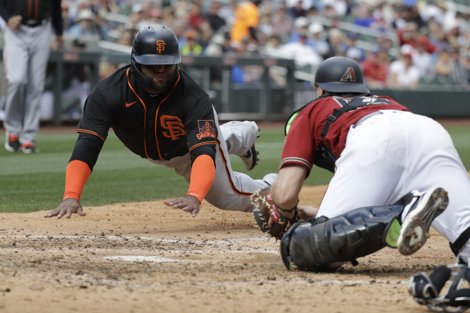 San Francisco Giants' Pablo Sandoval slides safe into home ahead of the tag from Arizona Diamondbacks' John Hicks during the fifth inning of a spring training baseball game, Monday, March 2, 2020, in Scottsdale, Ariz.(AP Photo/Darron Cummings)