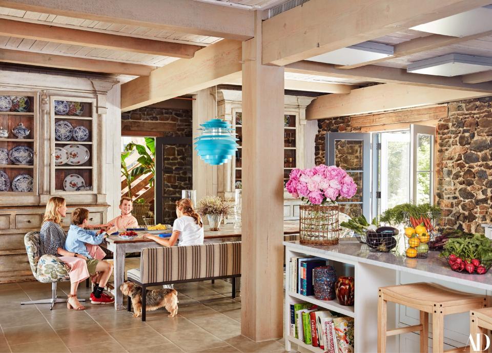 Buccini and the kids gather at the antique kitchen table under a 1950s Poul Henningsen pendant. Mati, left, sits in an Arne Jacobsen chair covered in a <a rel="nofollow noopener" href="http://www.bennisonfabrics.com/" target="_blank" data-ylk="slk:Bennison;elm:context_link;itc:0;sec:content-canvas" class="link ">Bennison</a> linen blend.