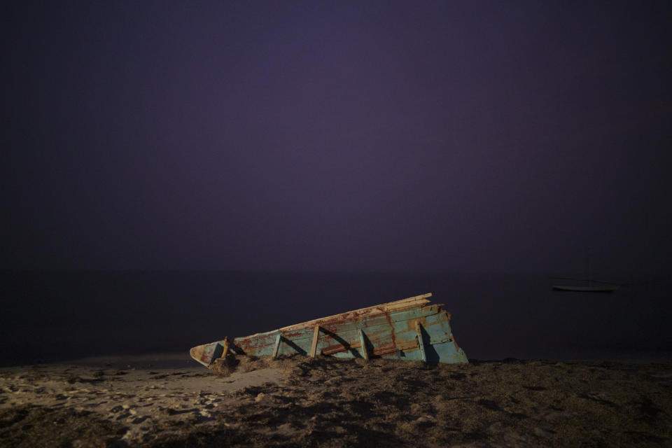 Parte del casco de una embarcación de pesca tradicional mauritana, llamada piragua, que también usan los migrantes para llegar a las Islas Canarias, en España, en una playa cerca de Nuadibú, Mauritania, el 2 de diciembre de 2021. En 2021, al menos siete embarcaciones del noroeste de África aparecieron en el Caribe y en Brasil. Todas llevaban cadáveres. (AP Foto/Felipe Dana)