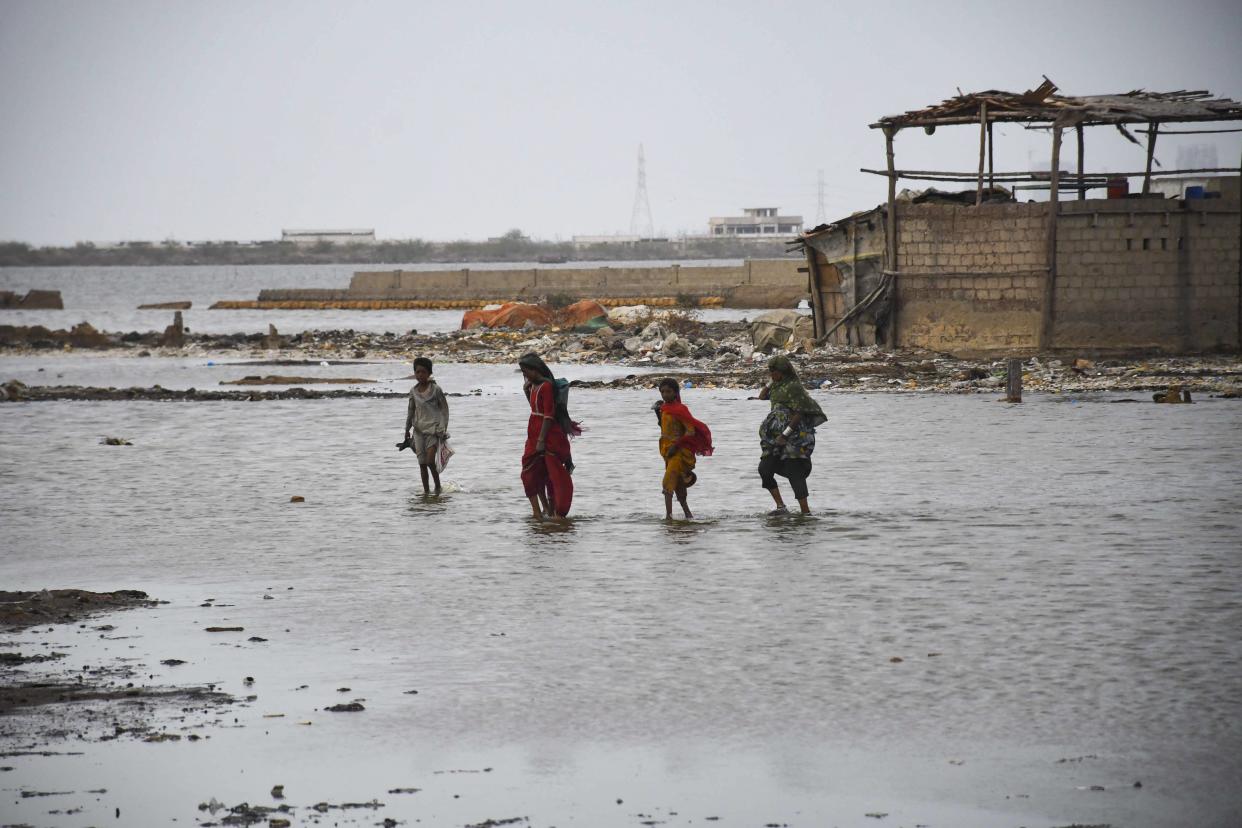 Pakistani flood victims cross sea water due to Cyclone Biparjoy approaching to the costal area in Karachi, Pakistan (Anadolu Agency via Getty Images)