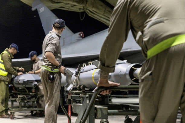 A handout picture released by the British Ministry of Defence (MOD) on 24 February 2024 shows a Royal Air Force Typhoon FGR4 having Paveway IV weapons loaded by Weapon Technicians at RAF Akrotiri in Cyprus, in preparation for a strike on military targets in Yemen, on 22 February 2024 (AFP via Getty Images)