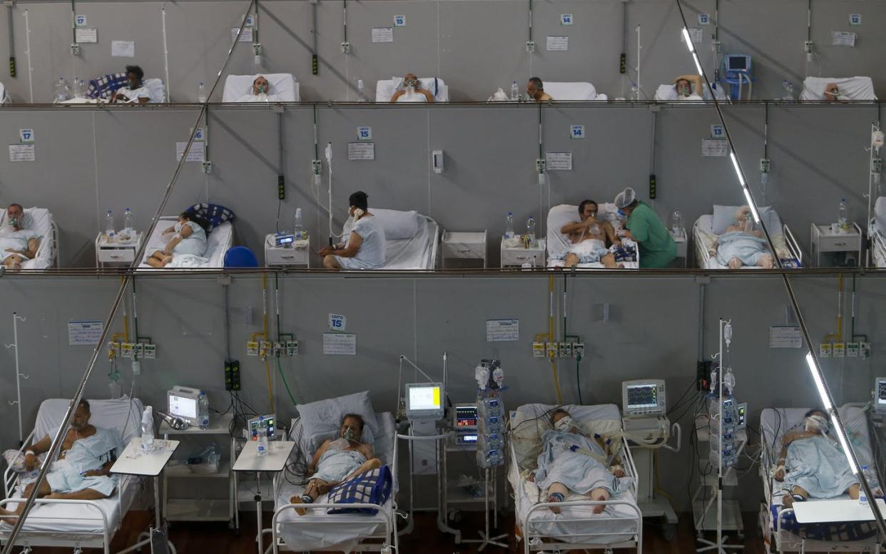 <span class="caption">A field hospital in São Paulo state, Brazil, on March 26, 2021. Brazil keeps setting new COVID-19 records, with up to 4,000 people dying daily. </span> <span class="attribution"><a class="link " href="https://www.gettyimages.com/detail/news-photo/patients-affected-by-the-covid-19-coronavirus-remain-at-a-news-photo/1231952275?adppopup=true" rel="nofollow noopener" target="_blank" data-ylk="slk:Miguel Schincariol/AFP via Getty Images;elm:context_link;itc:0;sec:content-canvas">Miguel Schincariol/AFP via Getty Images</a></span>