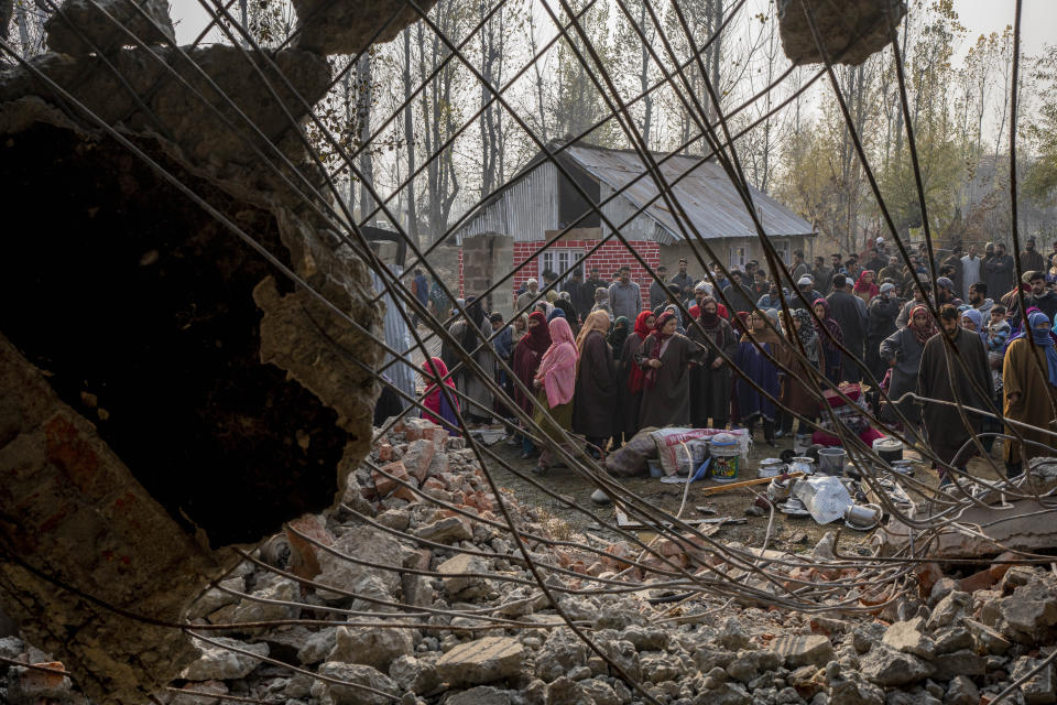 Kashmiri villagers inspect the debris of a damaged residential house where suspected rebels had taken refuge, after a gunfight in Kulgam south of Srinagar, Indian controlled Kashmir, Friday, Nov. 17, 2023. Police in Indian-controlled Kashmir said government forces killed five suspected militants in a gunbattle on Thursday. (AP Photo/Dar Yasin)