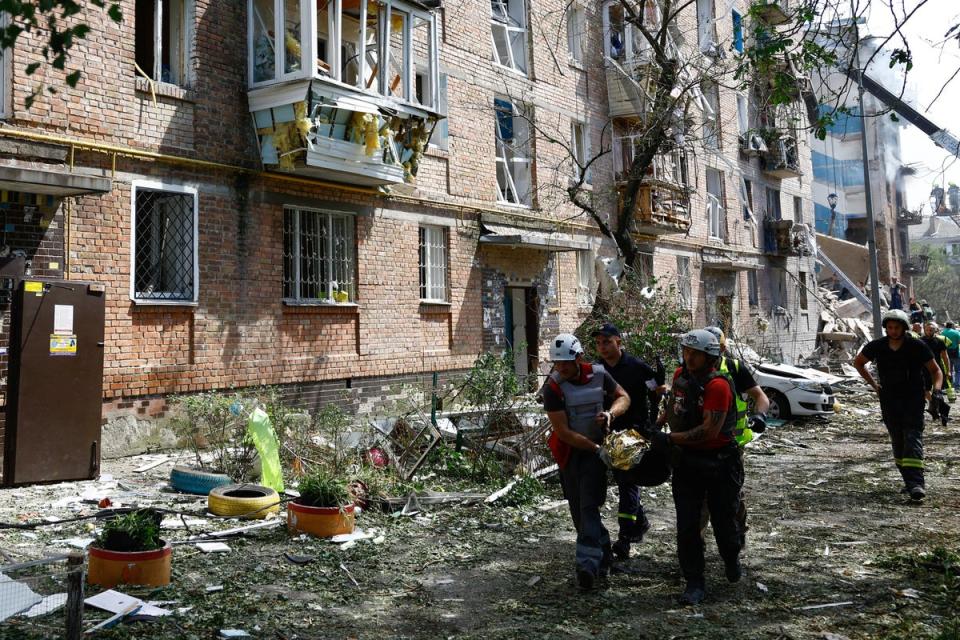 Medics carry a body of a child killed during Russian missile strikes (REUTERS)