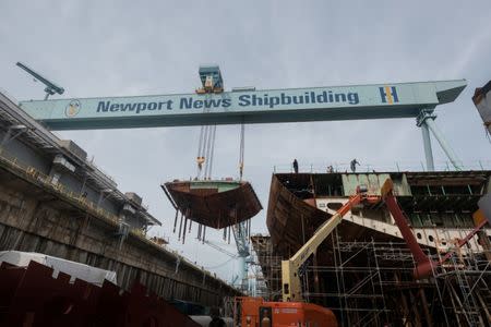 A crane moves the lower stern into place on the nuclear-powered aircraft carrier USS John F. Kennedy (CVN 79) at Huntington Ingalls Shipbuilding in Newport News, Virginia, U.S., in this June 22, 2017 handout photo. John F. Kennedy is the second Gerald R. Ford-class aircraft carrier which is now 50 percent structurally complete. U.S. Navy/Handout via REUTERS