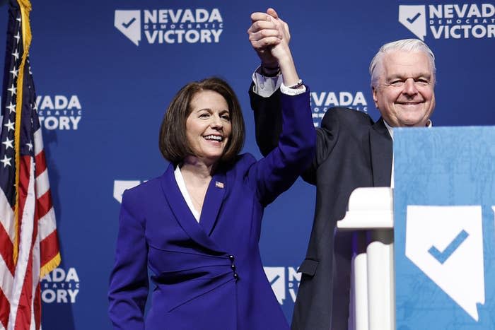 Sen. Catherine Cortez Masto and Nevada Gov. Steve Sisolak hold their hands up after giving remarks at an election night party on Nov. 8, 2022, in Las Vegas.