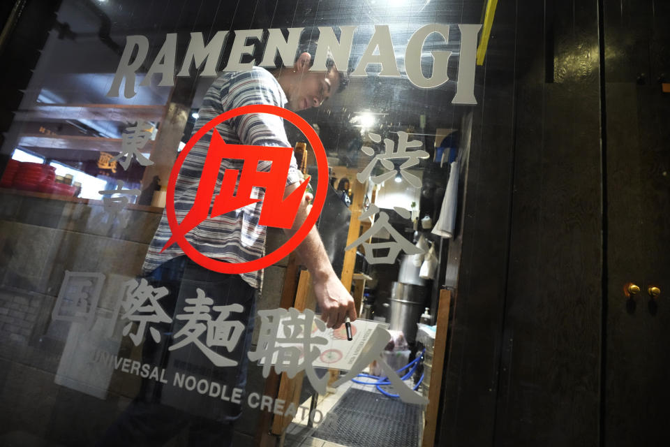 Frank Striegl, a guide of Tokyo Ramen Tours, walks inside Nagi, which offers "Fukuoka fusion," type ramen at Shibuya district on April 2, 2024, in Tokyo. (AP Photo/Eugene Hoshiko)