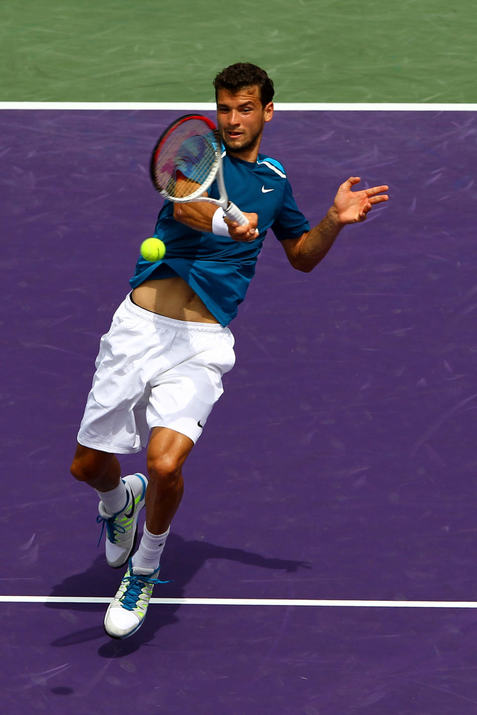 KEY BISCAYNE, FL - MARCH 25: Grigor Dimitrov of Bulgaria hits a return to Tomas Berdych of the Czech Republic during Day 7 of the Sony Ericsson Open at Crandon Park Tennis Center on March 25, 2012 in Key Biscayne, Florida. (Photo by Al Bello/Getty Images)