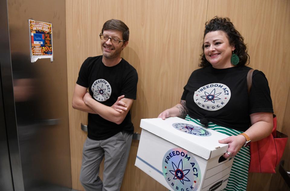 Joshua Shankles, left, and Morgan Kirkpatrick carry the Freedom Act Lubbock petition signatures to be delivered to the Lubbock city secretary, Tuesday, Oct. 17, 2023, at Citizens Tower.