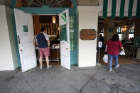 Patrons enter Cafe du Monde Coffee Stand in the French Quarter in New Orleans, Wednesday, Oct. 28, 2020. Businesses that were boarded up for previous hurricanes this season remain open this time as Hurricane Zeta approaches, expected to make landfall as a category 2 hurricane in the afternoon. (AP Photo/Gerald Herbert)