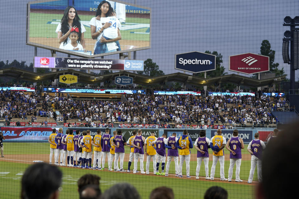 Members of the Los Angeles Dodgers wear Kobe Bryant jerseys during the national anthem as Kobe Bryant's family can be seen on the electronic board above prior to a baseball game between the Dodgers and the Atlanta Braves Friday, Sept. 1, 2023, in Los Angeles. (AP Photo/Mark J. Terrill)