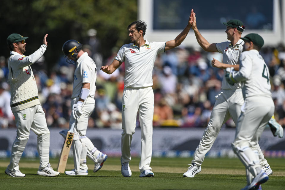 Mitchell Starc of Australia, centre, is congratulated by teammates after taking the wicket of New Zealand's Will Young, second left, on day two of the second cricket test between New Zealand and Australia in Christchurch, New Zealand, Saturday, March 9, 2024. (John Davidson/Photosport via AP)