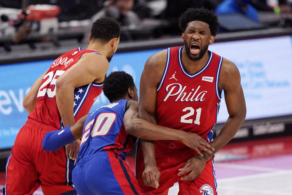 Philadelphia 76ers center Joel Embiid (21) grimaces after Detroit Pistons guard Josh Jackson (20) ran into him while chasing guard Ben Simmons (25) during the first half of an NBA basketball game Saturday, Jan. 23, 2021, in Detroit. (AP Photo/Carlos Osorio)