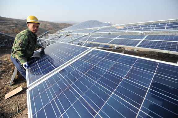 A worker installs solar panels in China's Shandong Province of China.