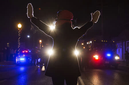 A female protester raises her hands while blocking police cars in Ferguson, Missouri, November 25, 2014. REUTERS/Adrees Latif