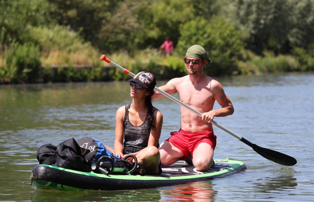 A pair of paddle boarders travel along the River Thames near Donnington Bridge, Oxford (PA)