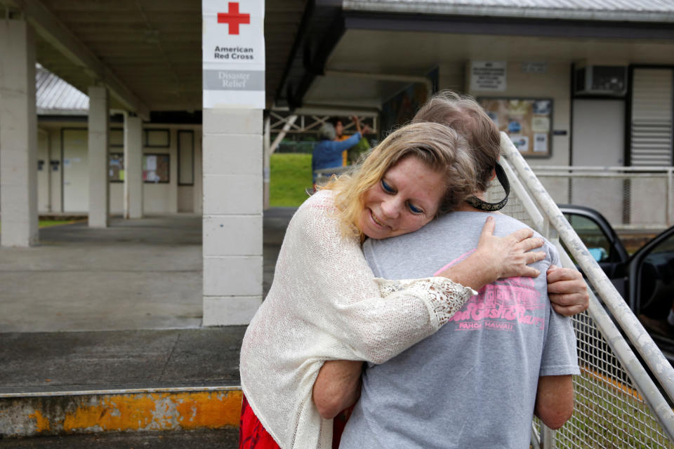 Carolyn McNamara, 70, hugs her neighbor Paul Campbell, 68, at an evacuation center in Pahoa after moving out of their homes in the Puna community of Leilani Estates on&nbsp;Friday.