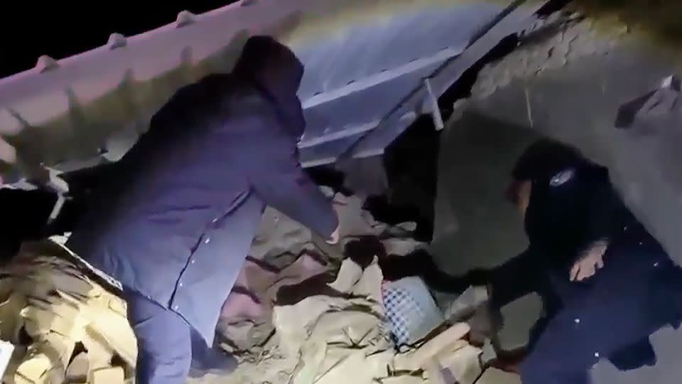 A screengrab of footage from CCTV shows rescuers working in rubble. - CCTV/AP